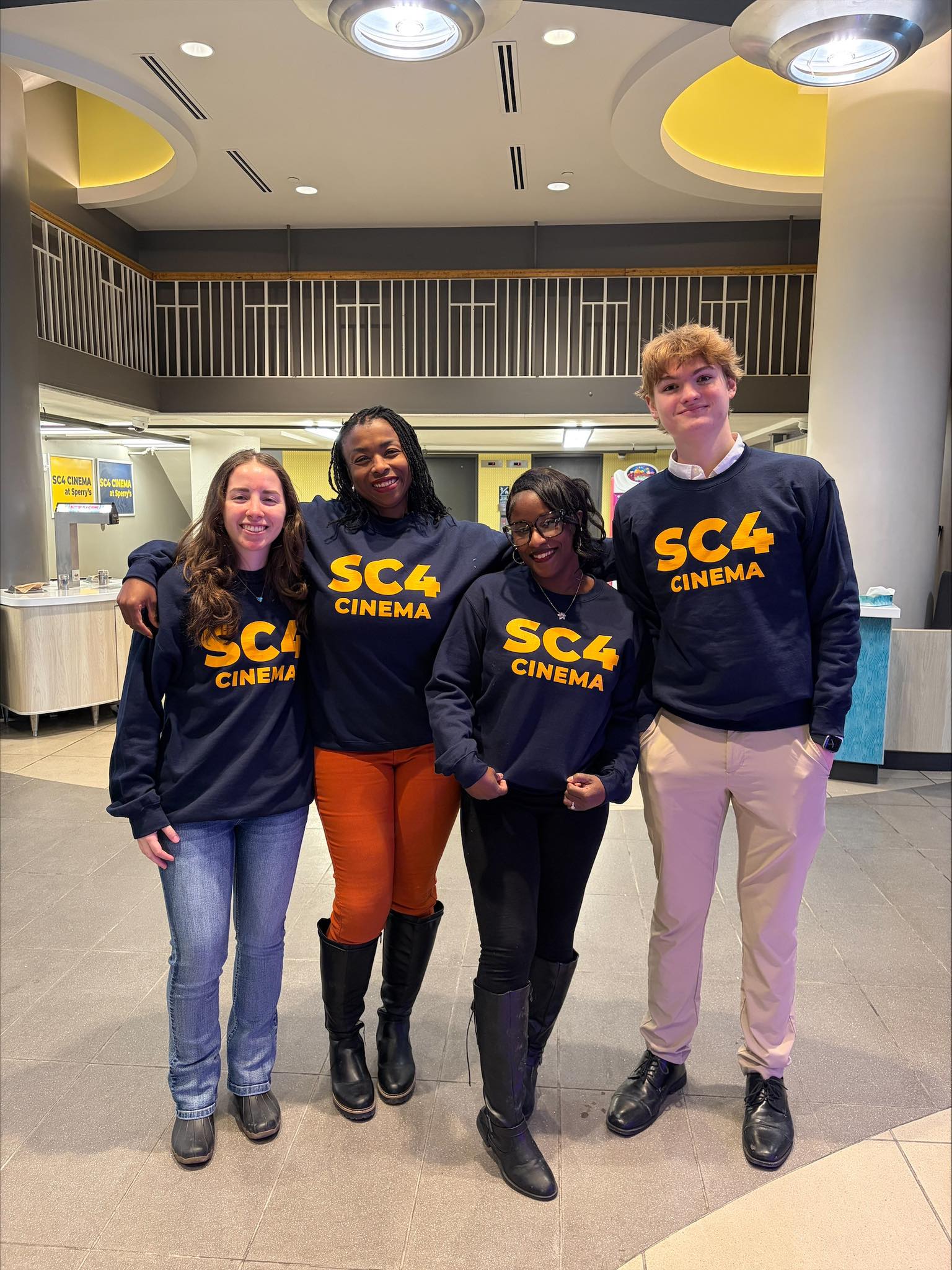 4 people standing in the cinema lobby. 